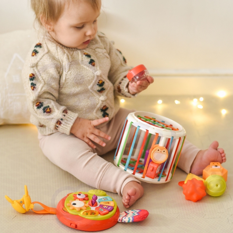 Vaikas-tyrinėja-interaktyvų-žaislą-su-spalvomis